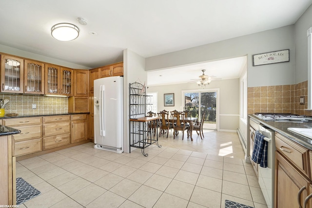 kitchen with backsplash, white refrigerator with ice dispenser, dark countertops, and light tile patterned flooring