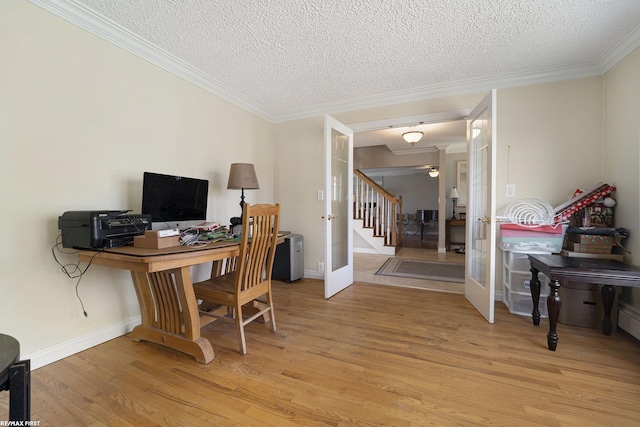 home office featuring crown molding, french doors, light wood finished floors, and a textured ceiling
