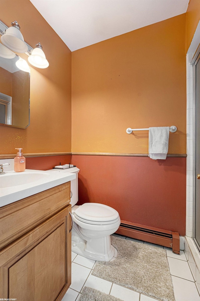 bathroom with toilet, vanity, tile patterned floors, a baseboard heating unit, and a shower with shower door