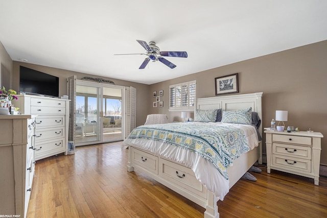 bedroom featuring a ceiling fan, wood finished floors, and access to exterior