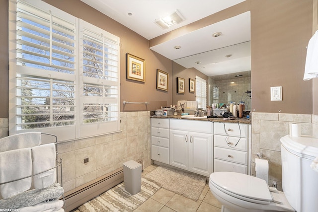 full bath featuring a baseboard radiator, a shower stall, tile walls, and tile patterned flooring