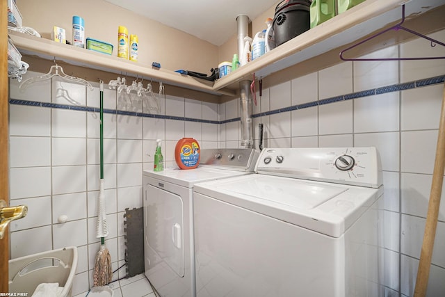 laundry room with washer and dryer, tile walls, and laundry area