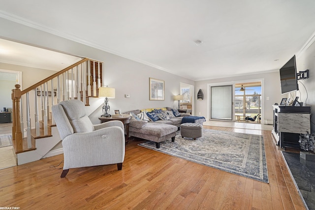 living room featuring stairway, wood-type flooring, and ornamental molding