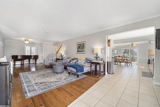 living room with ornamental molding and ceiling fan