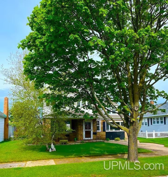 view of front facade featuring a front yard and fence