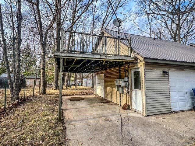 exterior space with aphalt driveway, a garage, and metal roof