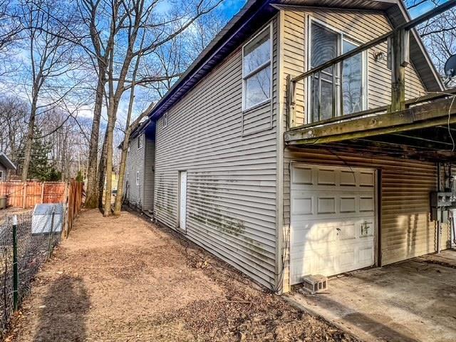view of home's exterior featuring an attached garage and fence