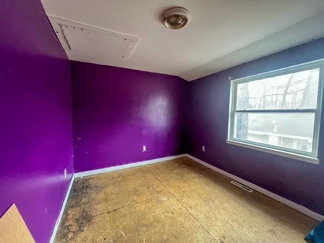 empty room featuring visible vents, attic access, and baseboards