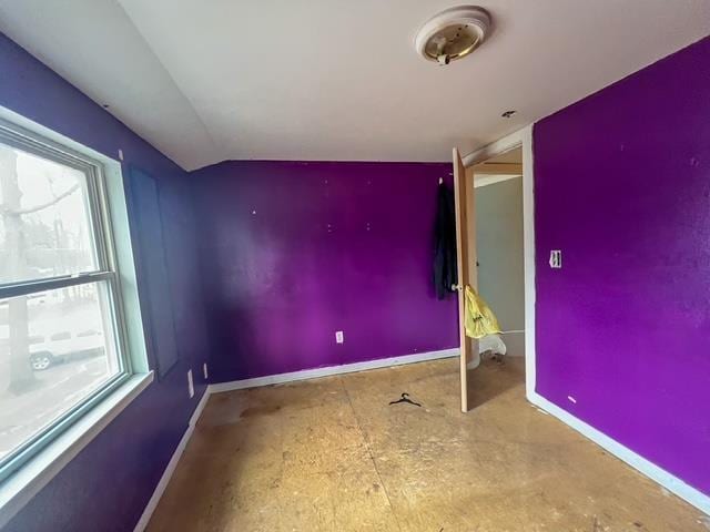 empty room with lofted ceiling and baseboards
