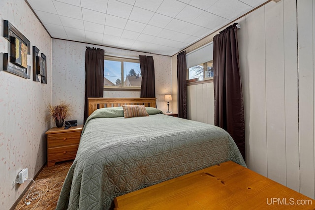 bedroom featuring wallpapered walls and multiple windows