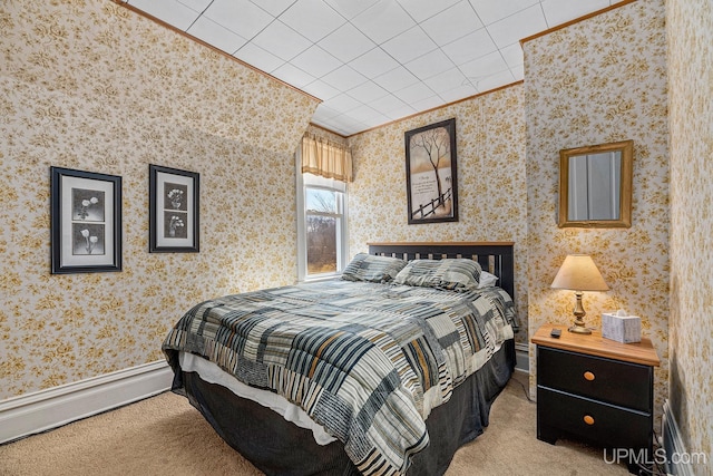 carpeted bedroom with a baseboard radiator, wallpapered walls, and crown molding