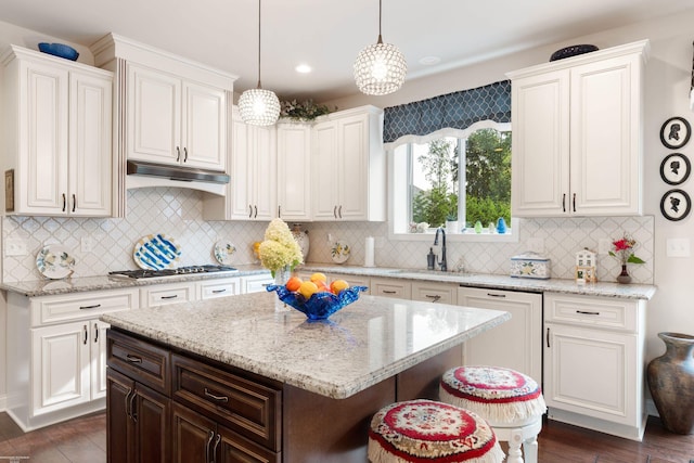 kitchen featuring white cabinetry, under cabinet range hood, a sink, and stainless steel gas stovetop