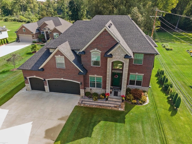 view of front of house with stone siding, a shingled roof, a front yard, and concrete driveway