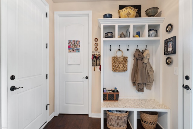 mudroom featuring dark wood finished floors and baseboards