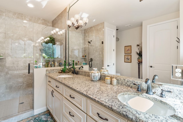 bathroom with double vanity, a shower stall, a notable chandelier, and a sink
