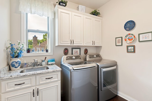 laundry room featuring cabinet space, washing machine and clothes dryer, and a sink
