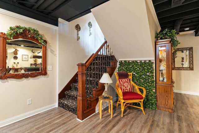 staircase with baseboards and wood finished floors