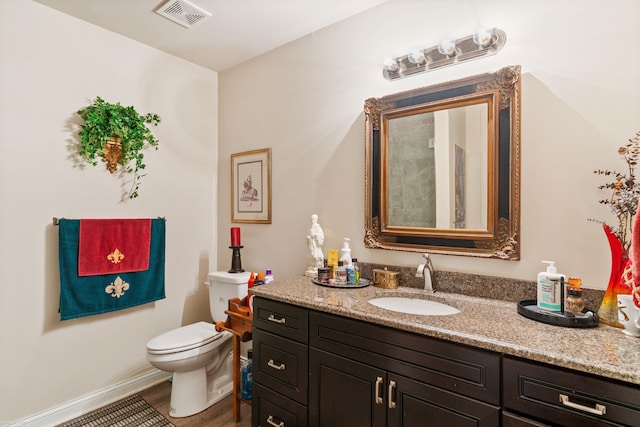 bathroom featuring wood finished floors, visible vents, toilet, and vanity
