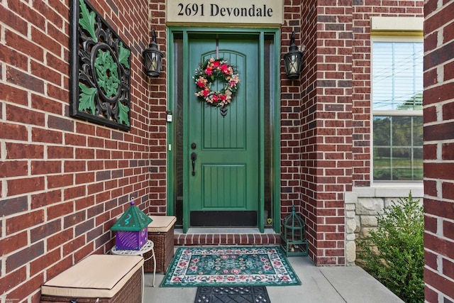 view of exterior entry featuring brick siding