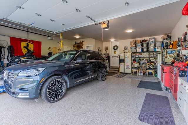 garage featuring white fridge with ice dispenser and a garage door opener
