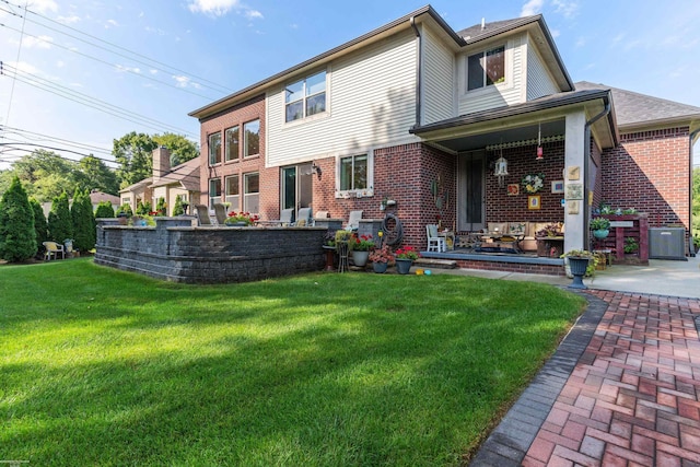 rear view of property with brick siding and a yard