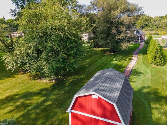 view of home's community with a barn, an outdoor structure, and a yard