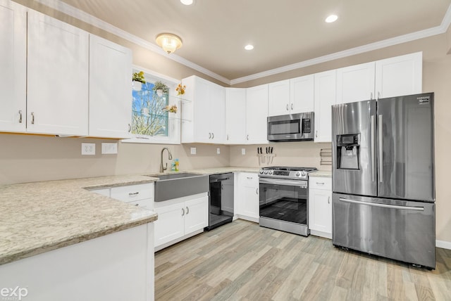 kitchen with white cabinets, light wood-style flooring, appliances with stainless steel finishes, and a sink