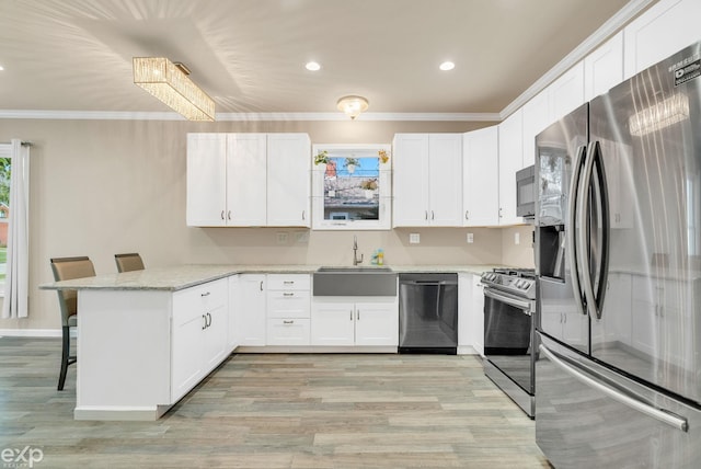 kitchen with crown molding, a kitchen breakfast bar, a sink, a peninsula, and appliances with stainless steel finishes