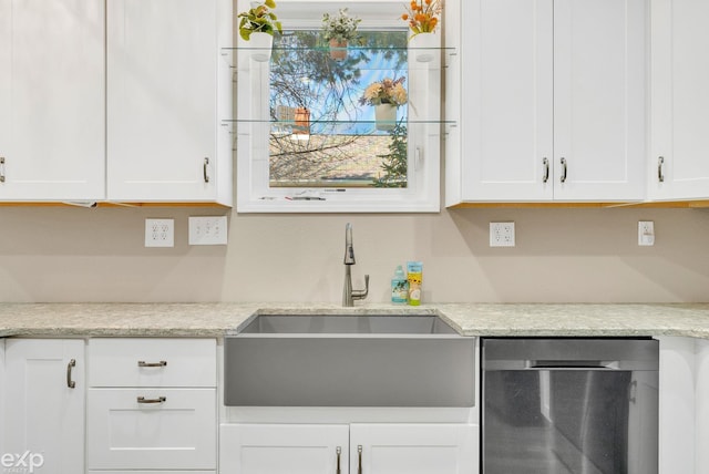 kitchen featuring white cabinets, stainless steel dishwasher, and a sink