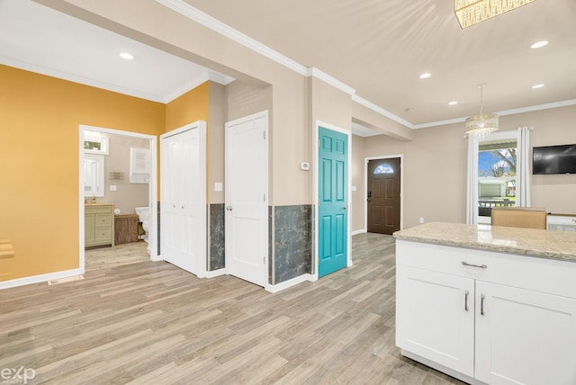 kitchen featuring white cabinets, recessed lighting, light wood finished floors, ornamental molding, and baseboards