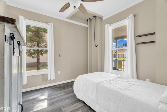 bedroom featuring baseboards, a ceiling fan, wood finished floors, and crown molding