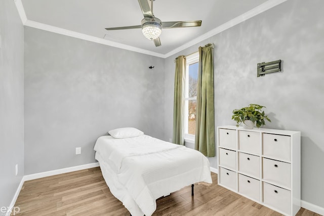 bedroom featuring ceiling fan, baseboards, crown molding, and wood finished floors
