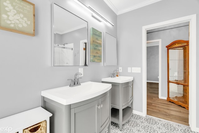 full bathroom featuring baseboards, two vanities, a sink, and crown molding