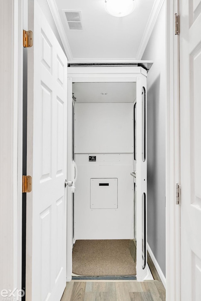 laundry area featuring crown molding, visible vents, and light wood-type flooring