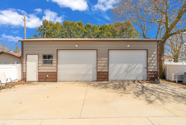 detached garage featuring fence