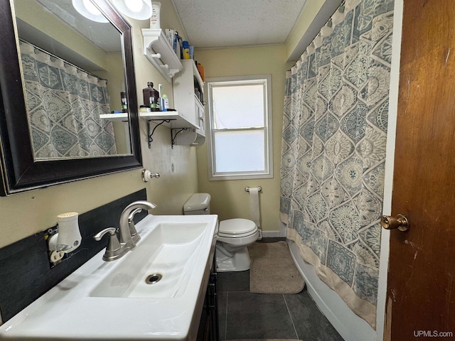 bathroom featuring toilet, vanity, tile patterned floors, and a textured ceiling