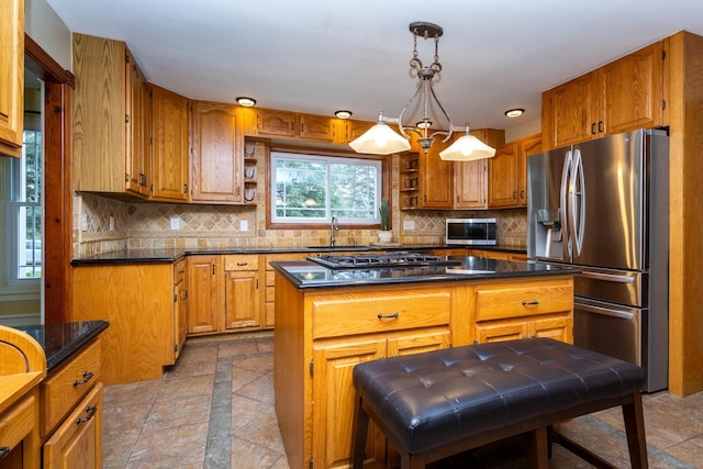 kitchen featuring brown cabinets, gas stovetop, stainless steel fridge, and backsplash