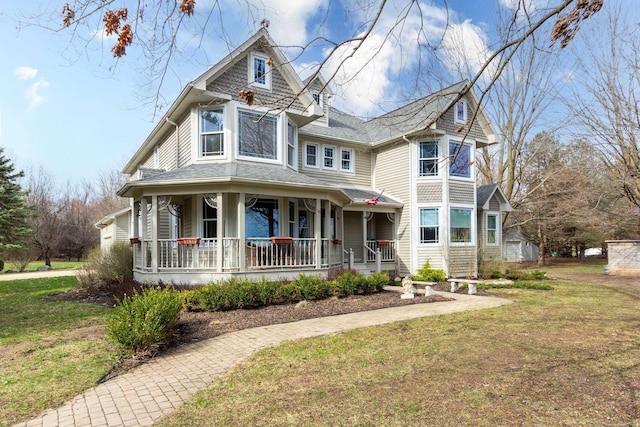 victorian house with a porch and a front lawn