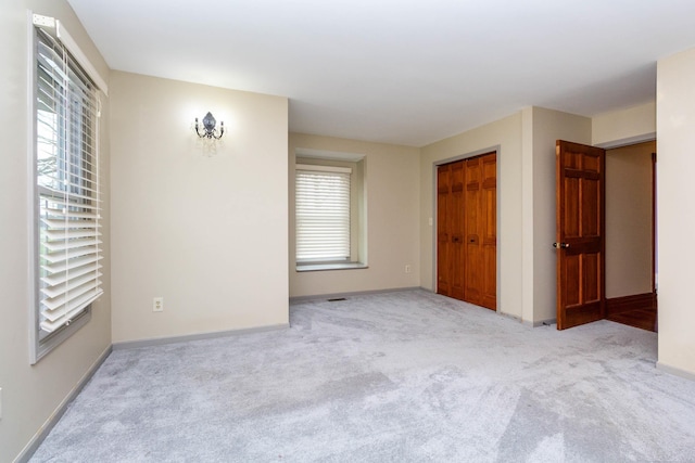 unfurnished bedroom featuring baseboards, carpet, and a closet