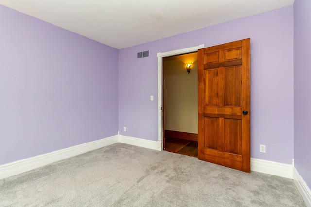 spare room with baseboards, carpet flooring, and visible vents
