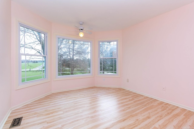 empty room with baseboards, visible vents, and light wood-style flooring