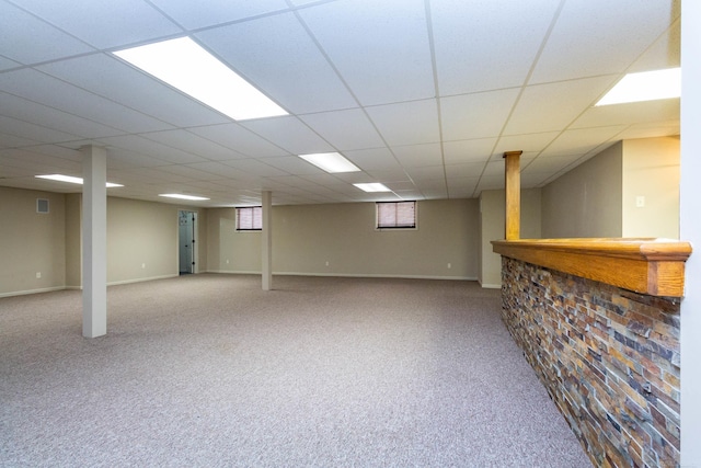 below grade area with visible vents, a dry bar, and carpet flooring