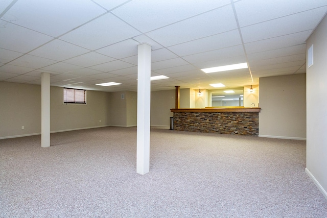 basement with carpet floors, a drop ceiling, and baseboards