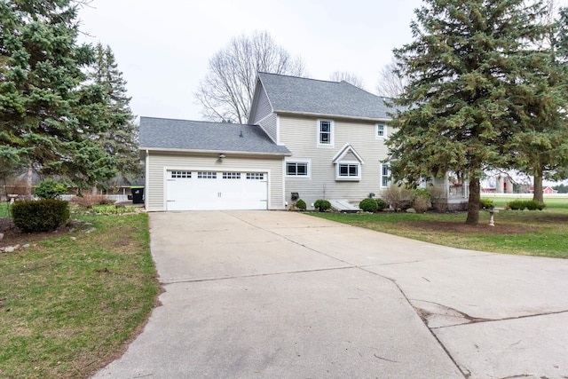view of front of home with a garage, driveway, a shingled roof, and a front yard