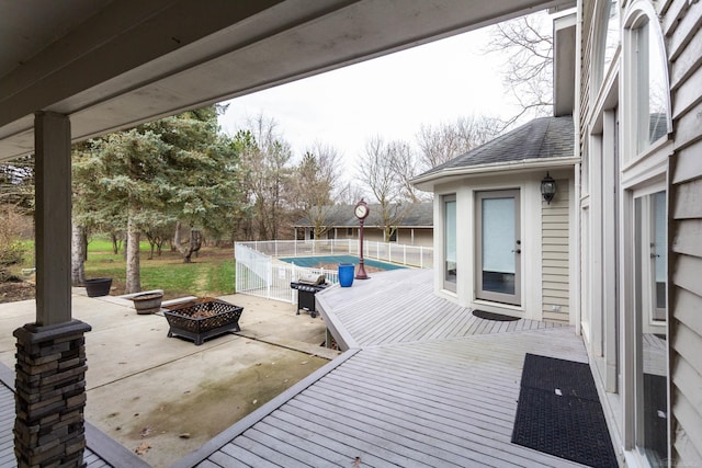view of patio with a deck, a fenced in pool, and an outdoor fire pit