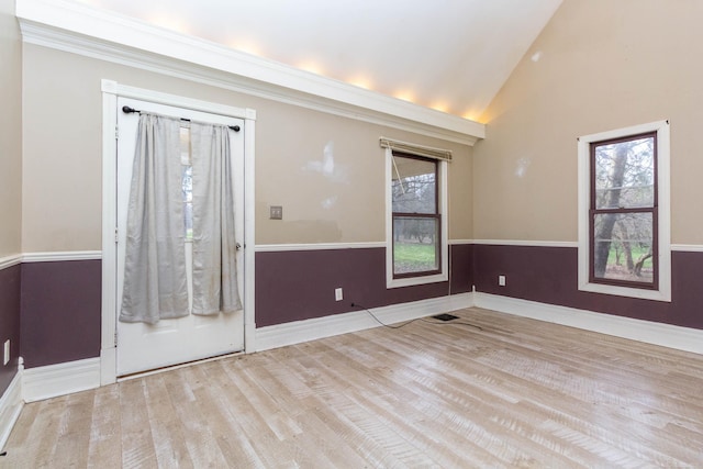unfurnished room with baseboards, vaulted ceiling, and wood finished floors