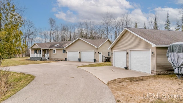 ranch-style home featuring an attached garage, a front yard, and covered porch