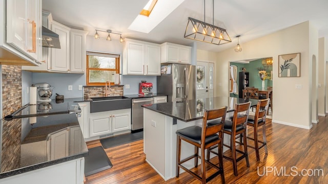 kitchen featuring a sink, white cabinetry, appliances with stainless steel finishes, and dark wood-style flooring
