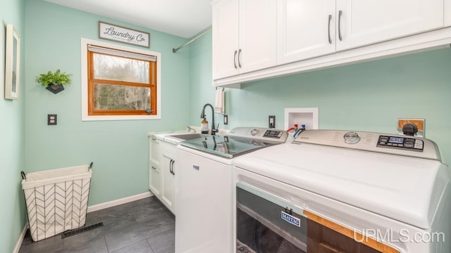 clothes washing area featuring cabinet space, baseboards, a sink, and separate washer and dryer