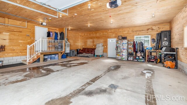 garage featuring wood walls and a garage door opener